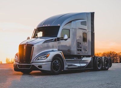 A silver sleeper cab truck with Hiring Our Heroes on the side.