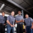 A diverse group of technicians in a truck shop.