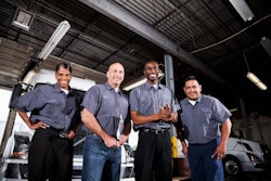 A diverse group of technicians in a truck shop.