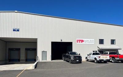A metal building with a sign that reads, 'ITP Inland Trucks Parts & Service' with three pickups parked in front.