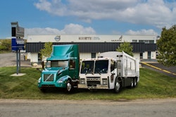 A teal Volvo Electric truck and a Mack electric refuse vehicle in front of Kriete Truck Center.