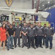 A group of people in front of a bucket truck.