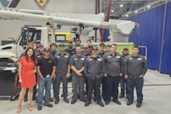 A group of people in front of a bucket truck.