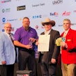 A group of men with an award, certificate and prizes at TMCSuperTech