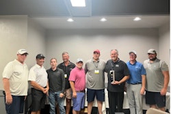 A group of people stand for a picture with an award.