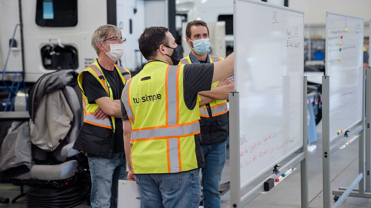 TuSimple employees working on a whiteboard