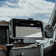 A plastic RAM Mount holds a tablet on the dash of a commercial truck.