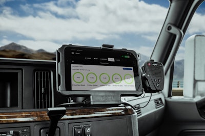 A plastic RAM Mount holds a tablet on the dash of a commercial truck.