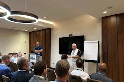 Two men present to a group of NTDA attendees in a hotel conference room.