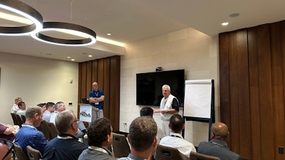 Two men present to a group of NTDA attendees in a hotel conference room.