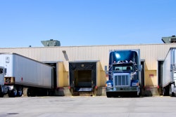 Three trucks parked against a fleet terminal