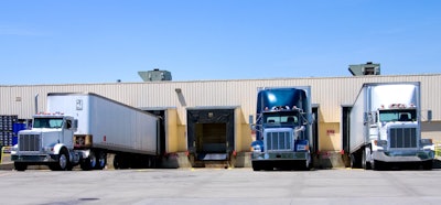Three trucks parked against a fleet terminal
