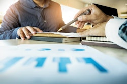 Customer being shown data on a sheet of paper