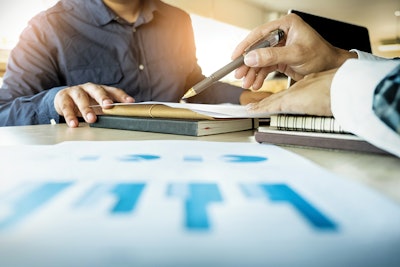 Customer being shown data on a sheet of paper