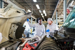 diesel mechanics looking under a hood