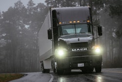 Mack truck on highway with headlights on