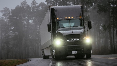 Mack truck on highway with headlights on