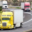 Four trucks of different colors driving on the highway