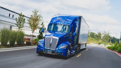 A blue Kenworth T680 hauling a trailer