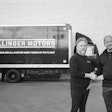Two men shake hands in front of a Bollinger Motors truck.