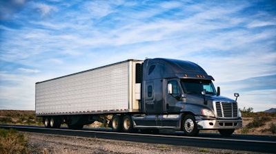 Freightliner Cascadia on a highway with clouds behind