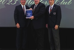 Three men from NationaLease stand on a stage holding an award.