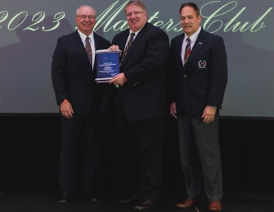 Three men from NationaLease stand on a stage holding an award.