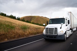 White truck driving down a hill in California