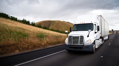 White truck driving down a hill in California