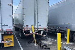 A truck and trailer with a parking bollard stuck in the back.