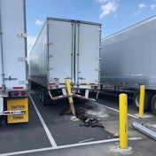 A truck and trailer with a parking bollard stuck in the back.