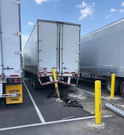 A truck and trailer with a parking bollard stuck in the back.