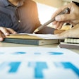 Man using pen to show data on a sheet to customer