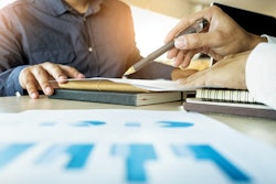 Man using pen to show data on a sheet to customer