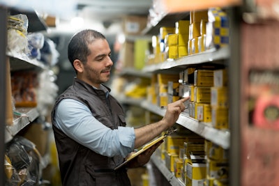 Man in warehouse counting boxes