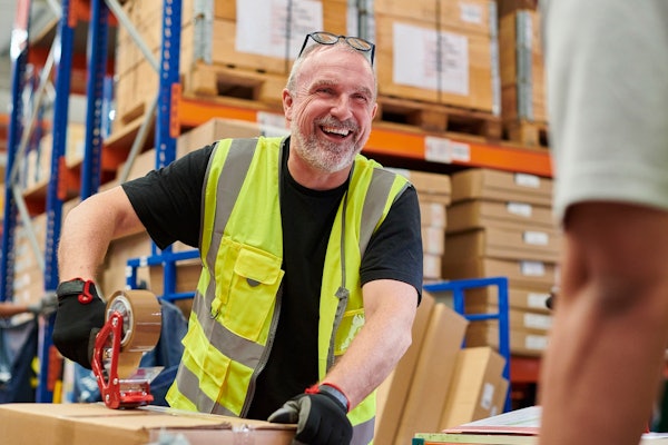 Man laughing working in warehouse