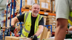 Man laughing working in warehouse