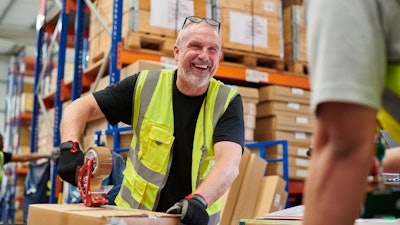 Man laughing working in warehouse