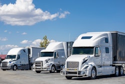 Three white trucks in a lot