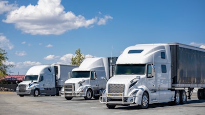 Three white trucks in a lot