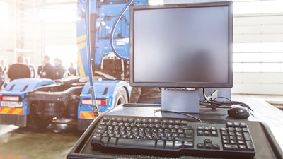 Computer in a service bay with a truck in the background