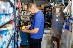 Man in a warehouse looking at part