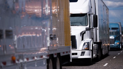 Three trucks in highway traffic