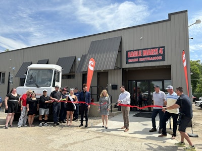A man cuts a ribbon in front of Eagle Mark 4.
