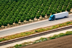 Truck on highway passing trees in California