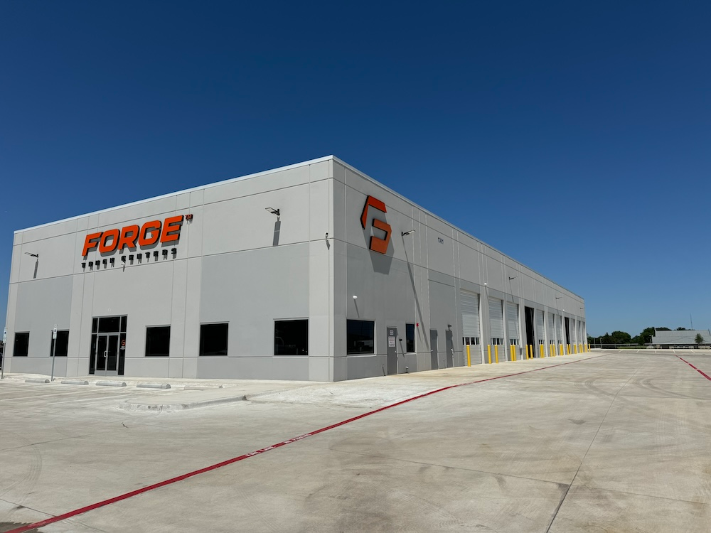 A large, gray building with the Forge Truck Centers logo