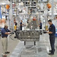 Two men work on either side of an engine in a Paccar factory in Mississippi.