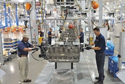 Two men work on either side of an engine in a Paccar factory in Mississippi.