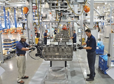 Two men work on either side of an engine in a Paccar factory in Mississippi.
