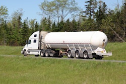 White truck with tanker trailer in country